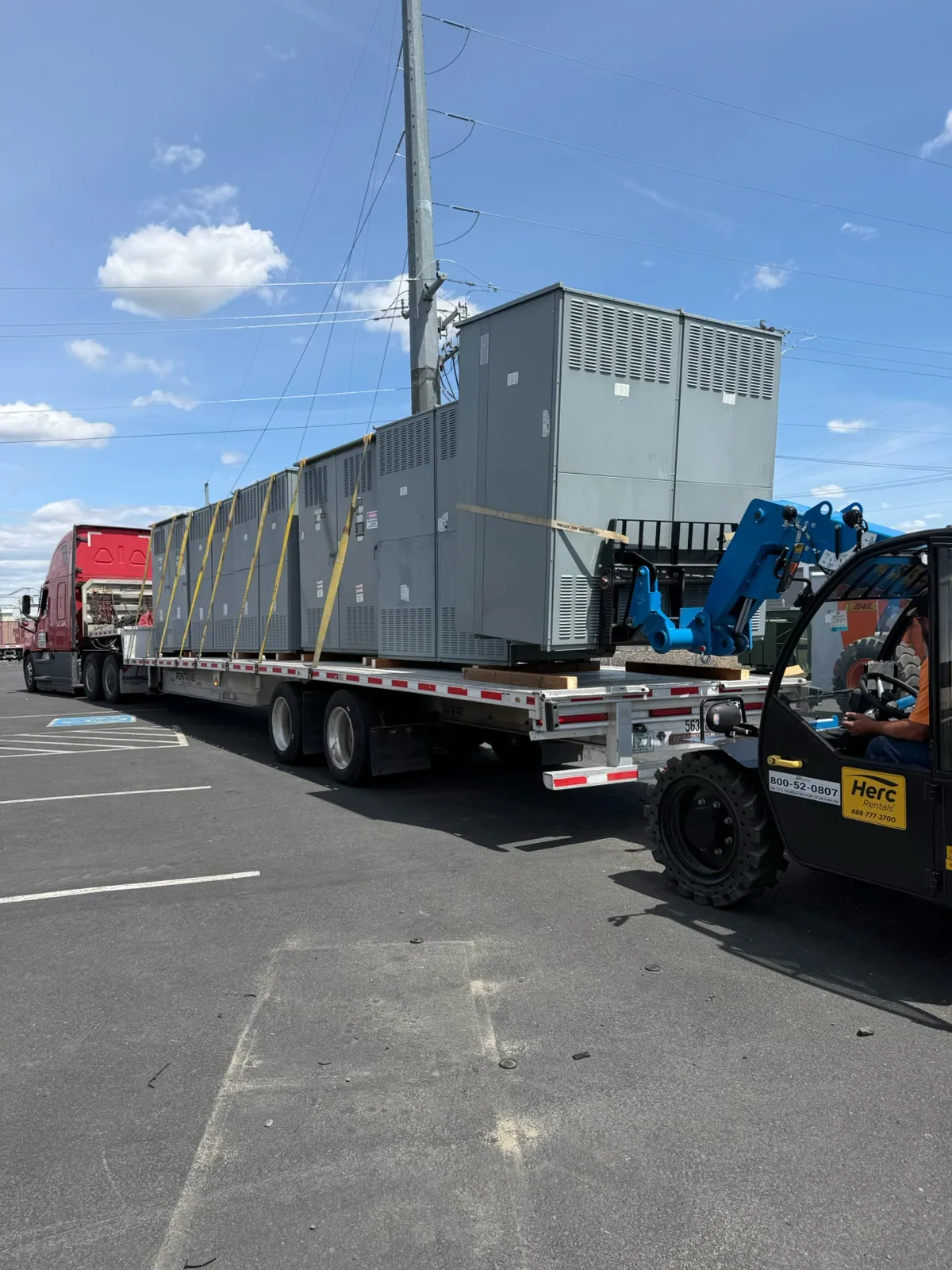 Switchgear sections loaded on a flatbed with a telehandler — Murrieta, CA