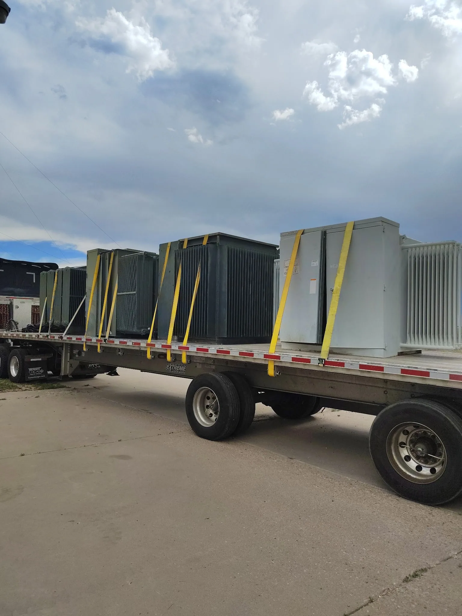 Transformers strapped to a flatbed trailer for load-out
